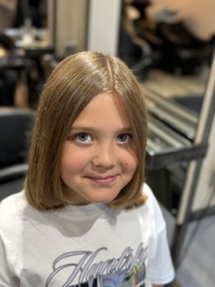 A smiling girl wearing an Ailsa's Aim T-shirt